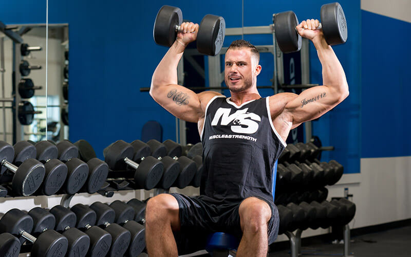 Muscle and Strength Athlete Performing Dumbbell Overhead Presses