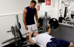 CAMP H.M. SMITH, Hawaii - Staff Sgt. Brett Garmon, G-4 air staff noncommissioned officer, U.S. Marine Corps Forces, Pacific, utilizes the bench press and weights, while safely being spotted by Master Sgt. Bill Atwater, G-4 maintenance management chief, MARFORPAC at the  Semper Fit Center here.